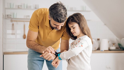 kind toont smartwatch aan papa